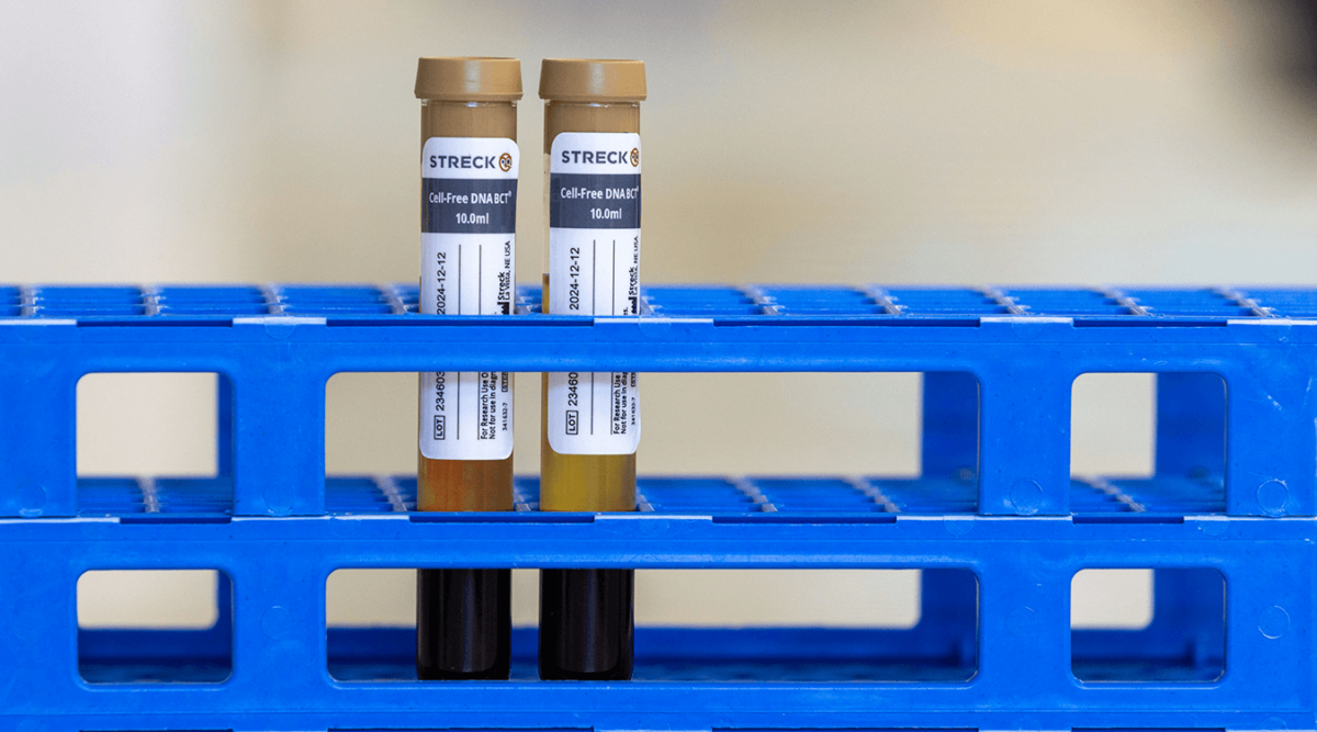 Two Cell-Free DNA BCT tubes in a blue stand in a lab environment.